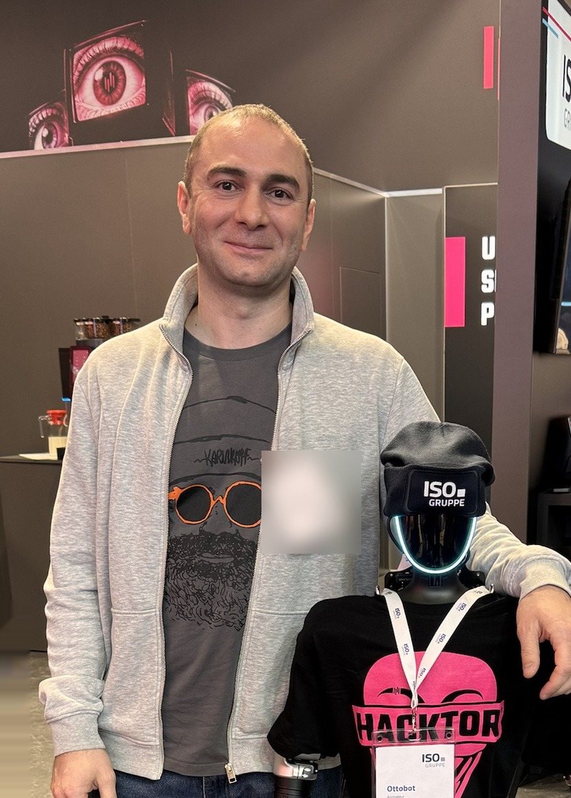 Rostislaw Kazas neben einem humanoiden Roboter auf einer Messe